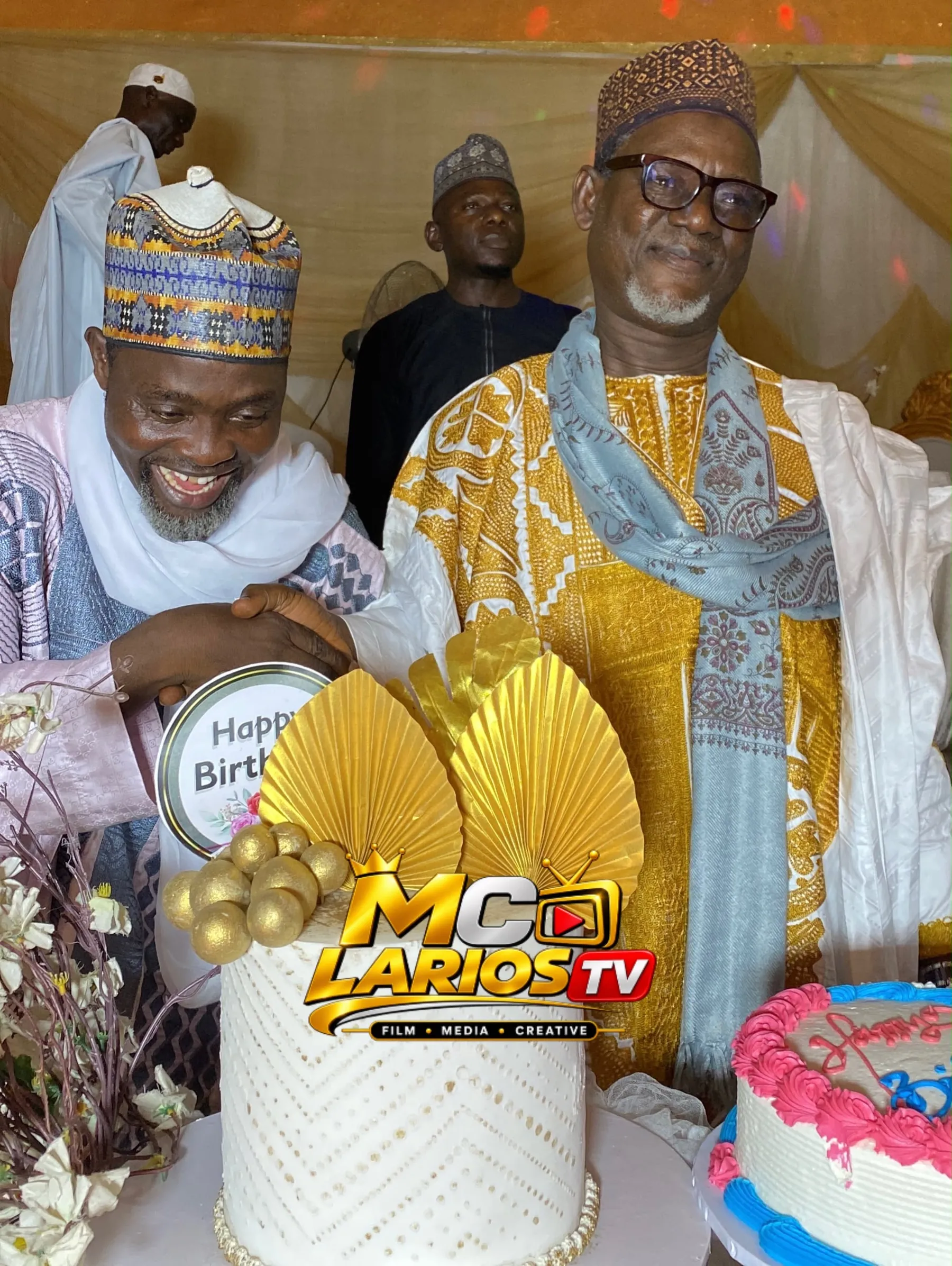Two elders shaking hands over a decorated cake