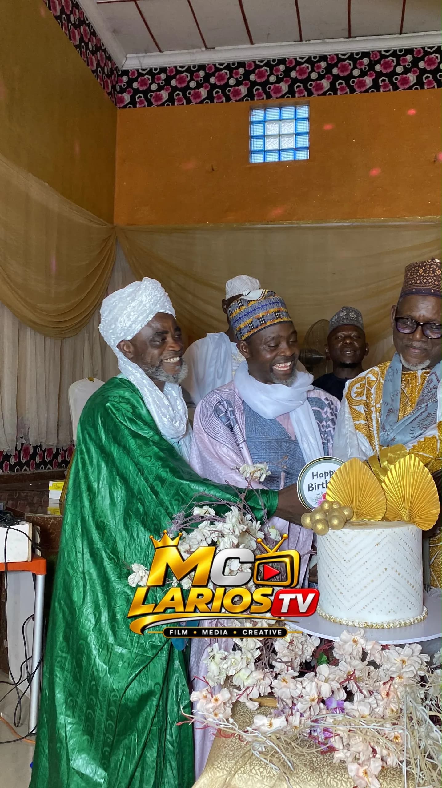 Elders cutting a decorated cake together