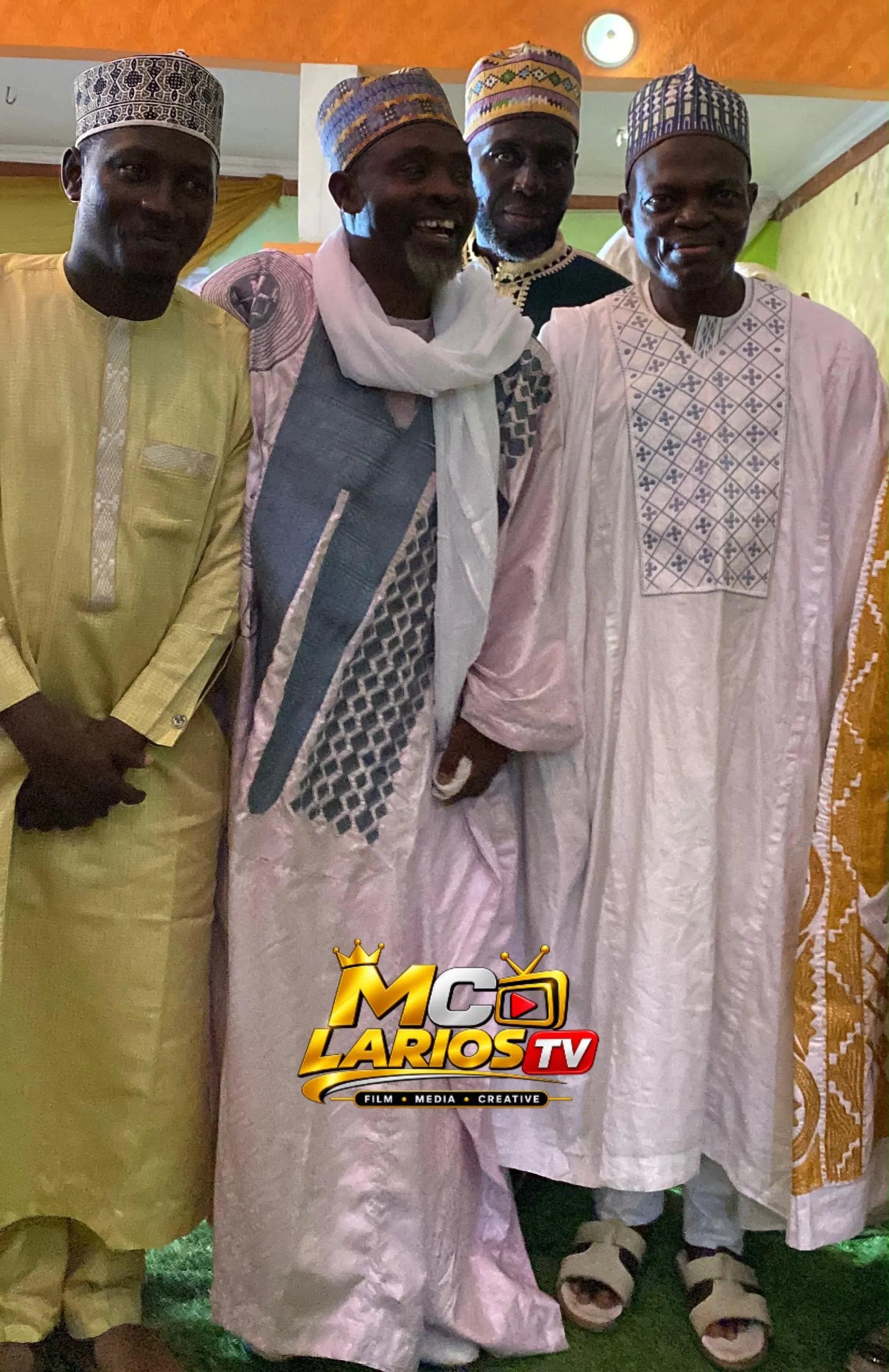Four men in embroidered robes and caps standing together
