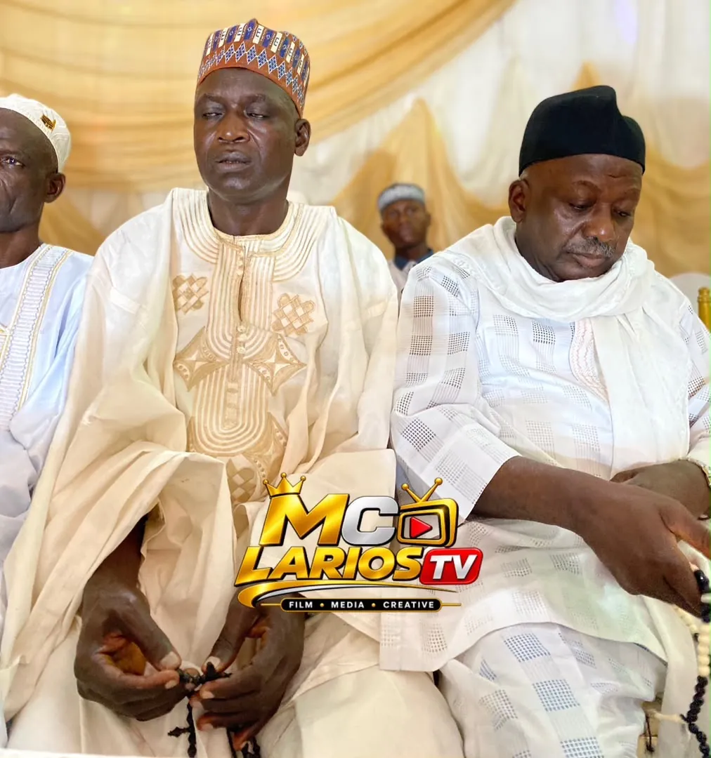Guests in white robes seated in the hall