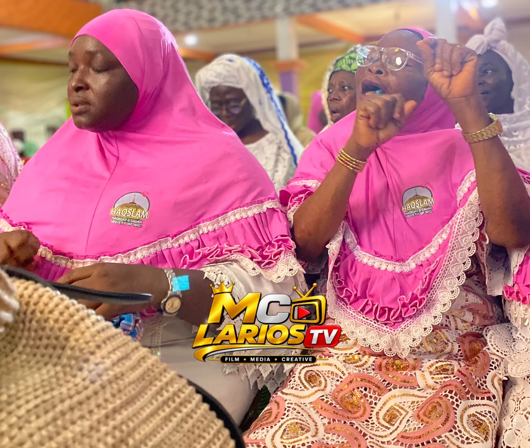 Women in pink hijabs in the audience